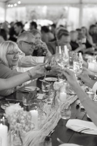 Guests cheering wine glasses at a wedding reception