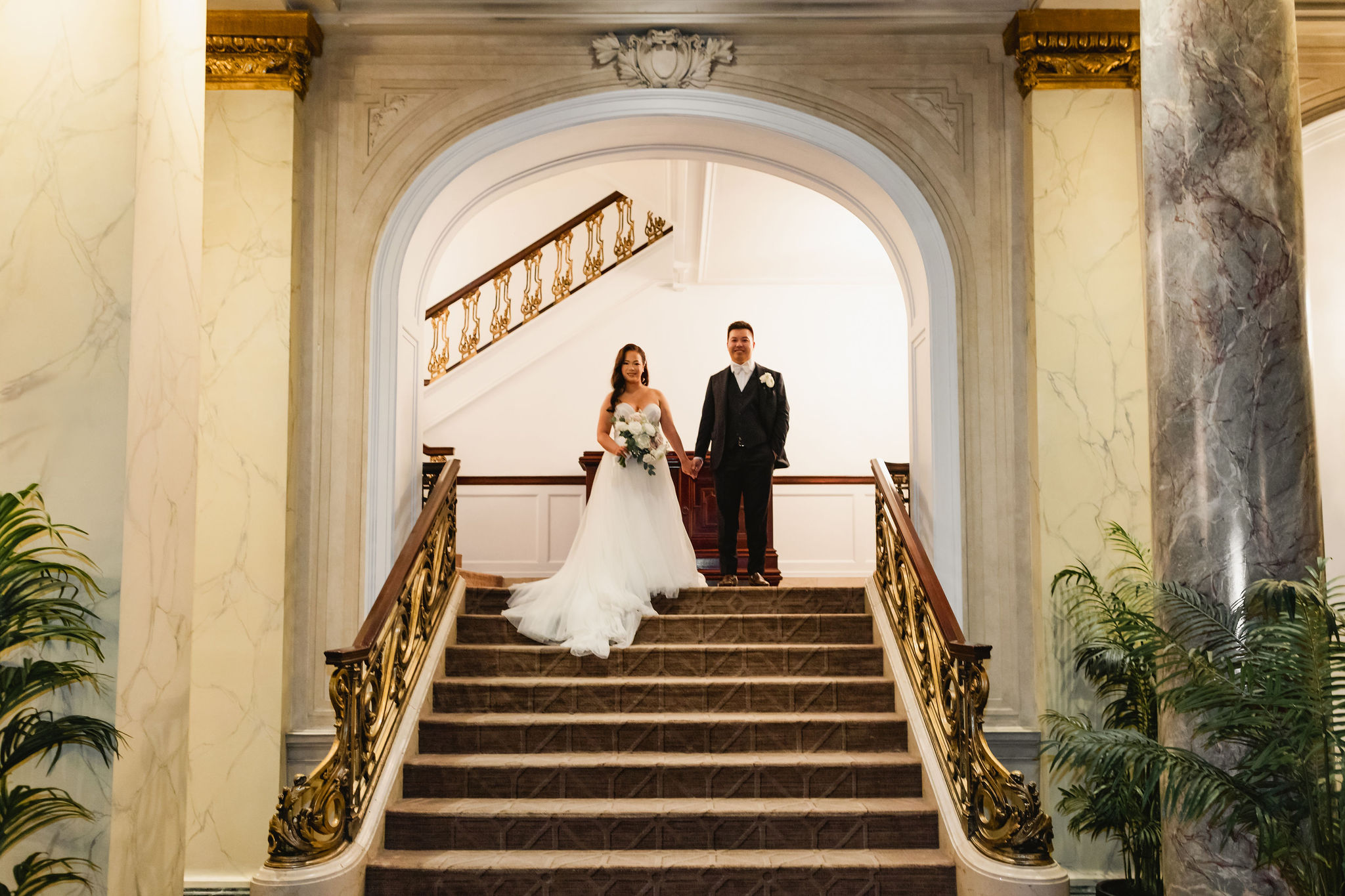 Newlyweds on the staircase within the Fairmont Palliser