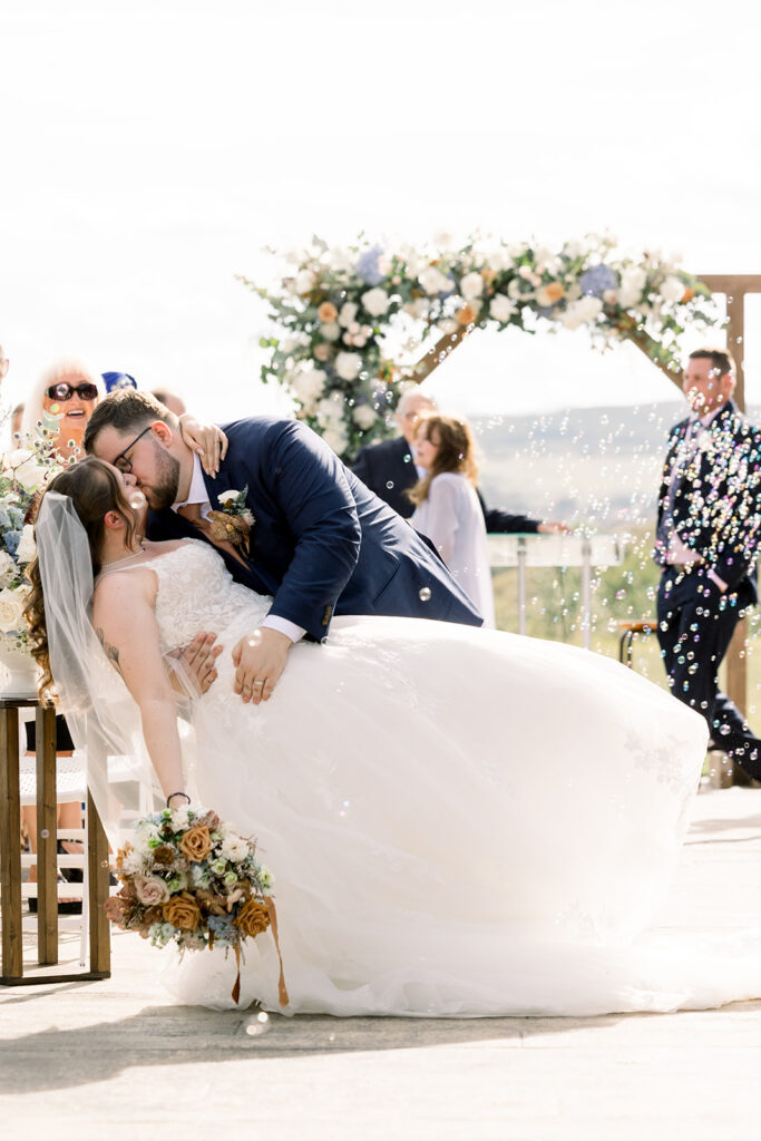 Newlyweds kissing at end of aisle