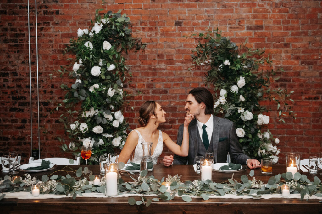 Newlyweds embracing at their sweetheart table