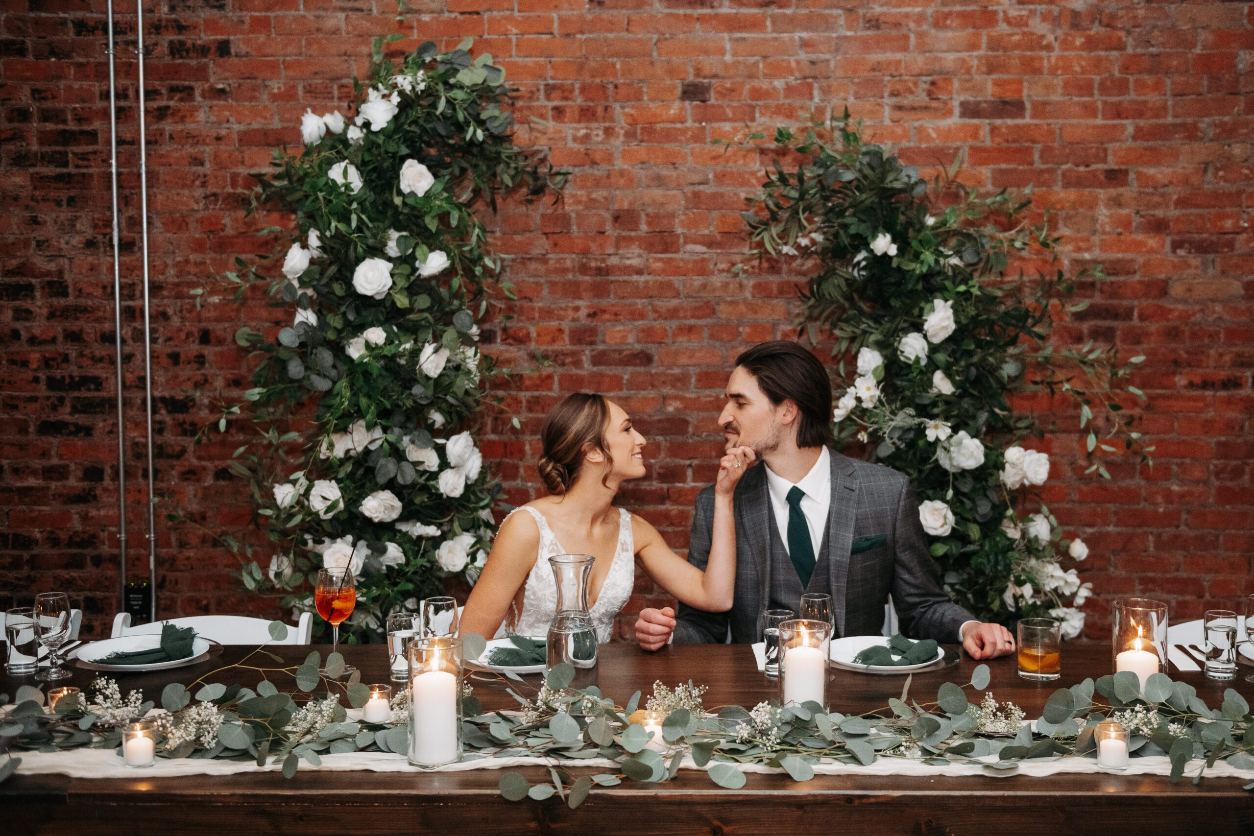 Newlyweds embracing at their sweetheart table