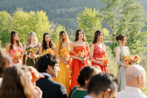 bridesmaids in colourful dresses standing at ceremony